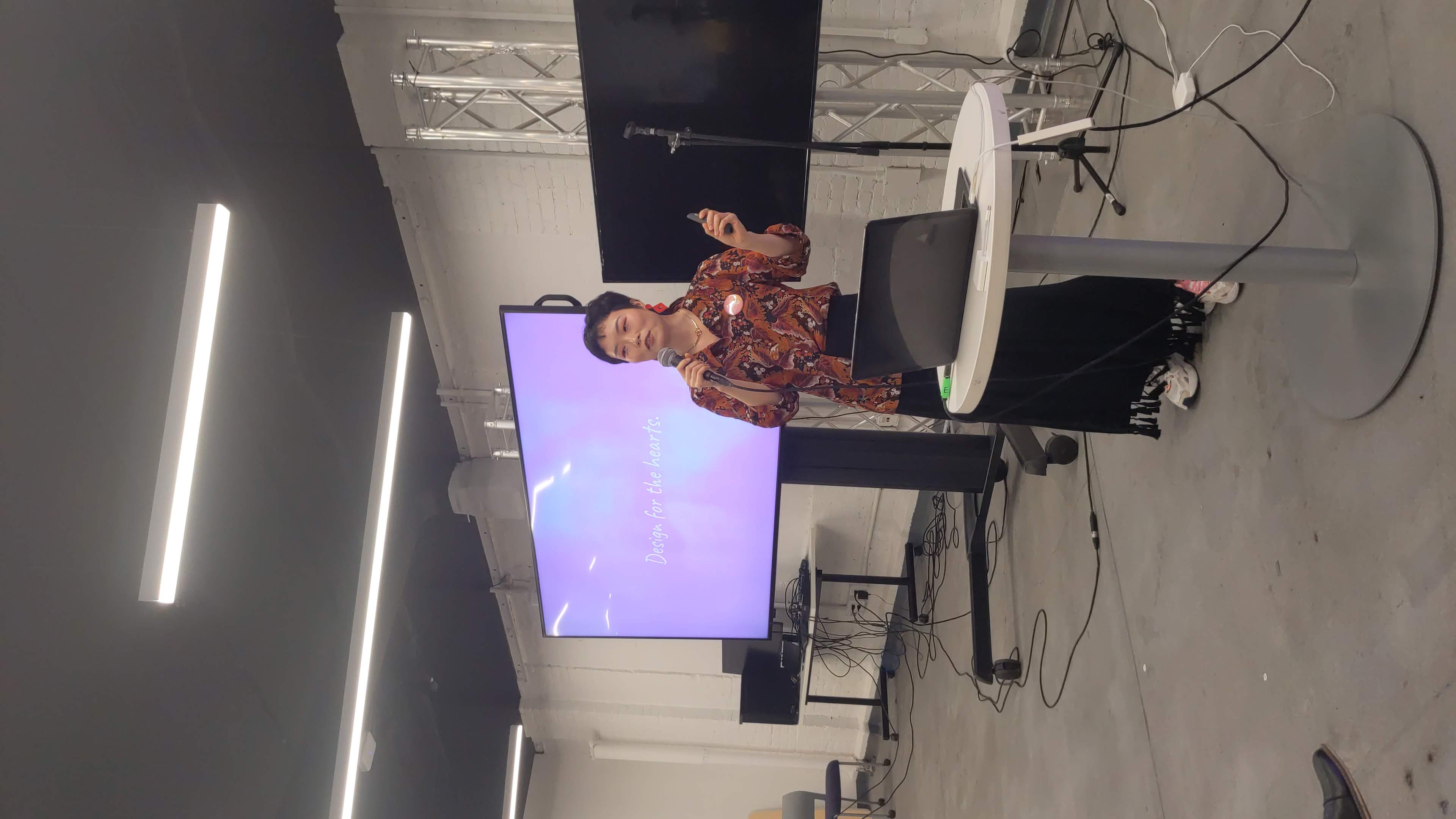 Yiting Liu giving an XR Guild talk with a Design for the hearts slide behind her